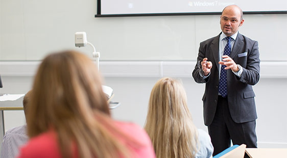 A lecturer presenting to a group of students